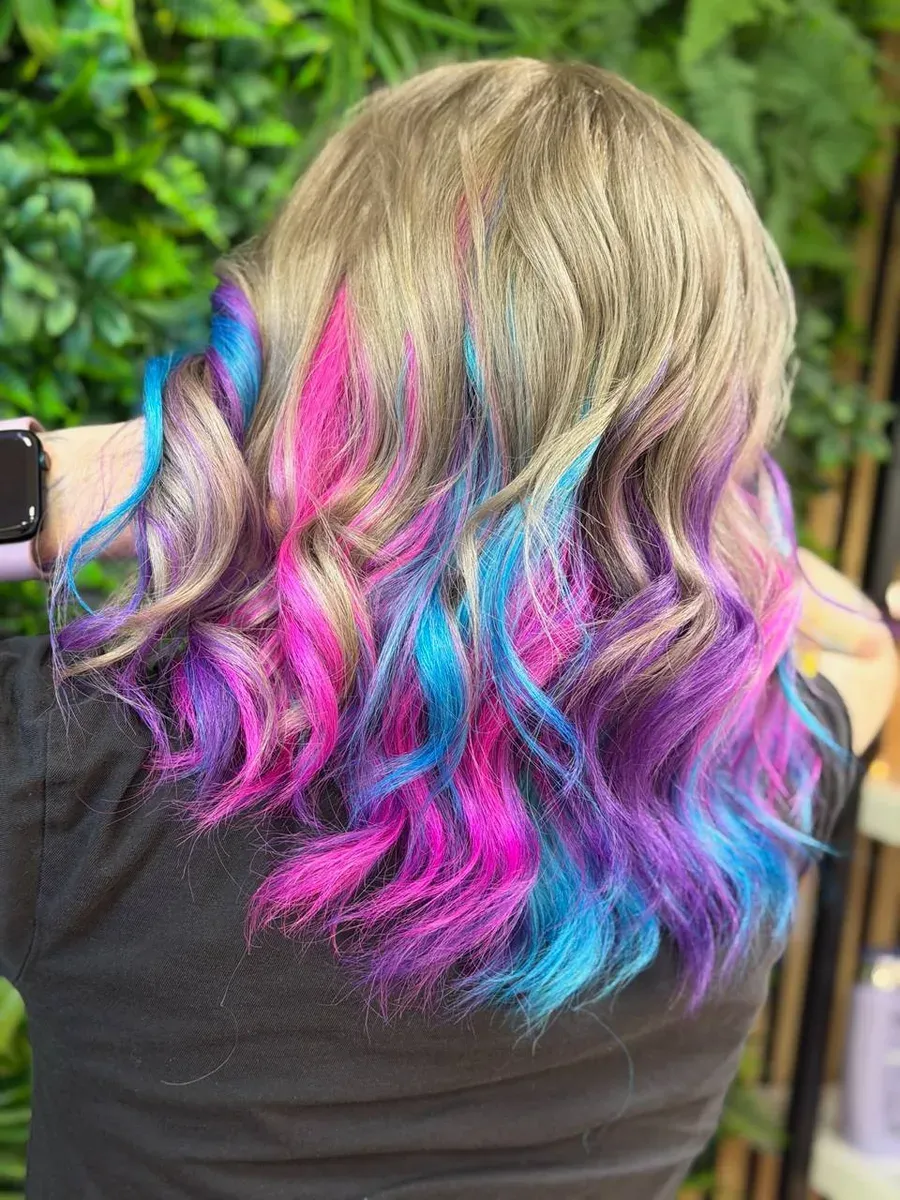 Frau mit leuchtendem Elumen-Haar in Pink, Blau und Violett — Rückansicht mit Wellen